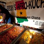 A woman sells food from Ghana at a market in Berlin. (AFP)