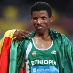 Haile Gebrselassie celebrating with his national flag after competing in the men's 10 000m final at the "Bird's Nest" National Stadium during the 2008 Beijing Olympics. (AFP)