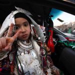 A Libyan girl in traditional tribal costume flashes the V-sign for victory as families parade in their cars through the streets of Tripoli in celebration on February 16 2012, the eve of the first anniversary of the revolt against Muammar Gaddafi. (AFP)