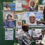 Malians look at posters displaying candidates for the upcoming presidential election. (Pic: AFP)