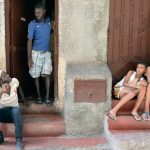 Senegalese immigrants and Moroccan children sit in front of a building where they rent flats in the Takaddum neighbourhood of Rabat. (Pic: AFP)