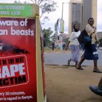 People walk past a poster bearing a message against rape on a street in Nairobi on November 24 2005. (Pic: AFP)