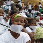 Women with their mouths covered with pieces of cloth gather on the steps of the National Assembly in Bangui to protest against violence against women. (Pic: AFP)