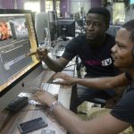 Video editors David Adeoti (L) and Jolaosho Oladimeji preview a work at the headquarters of Iroko tv in Lagos. (Pic: AFP)