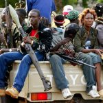 A pick-up with young soldiers loyal to then Liberian president Charles Taylor escorts Taylor's armoured SUV on a tour of the Monrovia defence line in June 2003. (Pic: AFP)
