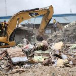 Beds used by guests are seen near an excavator at the site of the collapsed Synagogue Church of All Nations in Lagos on September 17 2014. (Pic: Reuters)