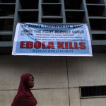 A woman passes a sign posted in an awareness campaign against the spread of Ebola in Freetown, Sierra Leone. (Pic: Reuters)