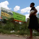 A woman walks past a billboard promoting male circumcision to combat Aids in the capital, Harare. (Pic: Reuters)