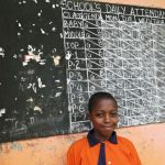 Ugandan schoolgirl Violet Nalubyayi stands in front of a black board in Lwengo on February 25 2014. (Pic: AFP)