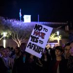 A man holds a placard as he and others attend a silent vigil against xenophobia, held at Constitution Hill in Johannesburg on April 21 2015. (Pic: AFP)